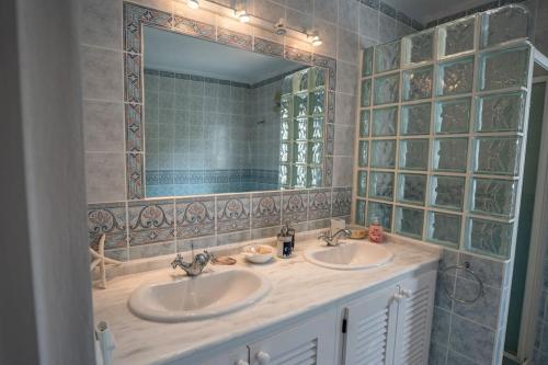 een badkamer met 2 wastafels en een grote spiegel bij Can Paradís in San Antonio