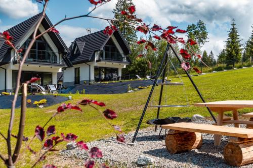 a swing and a picnic table in front of a house at Smrekowa Ostoja in Poronin