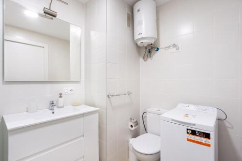 a white bathroom with a toilet and a sink at Home2Book Stylish Sea Views Studio Santa Cruz in Santa Cruz de Tenerife