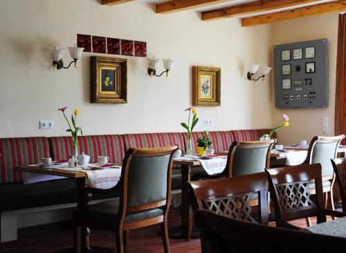 a restaurant with tables and chairs in a room at Hotel Schlossresidenz Heitzenhofen in Duggendorf