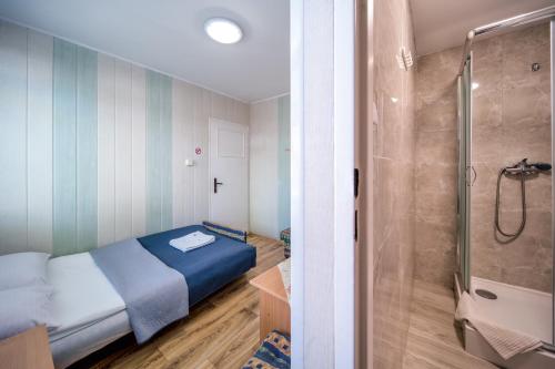 małą sypialnię z łóżkiem i prysznicem w obiekcie OW Gromada Pod Bukami w mieście Międzyzdroje