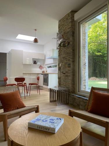 - un salon avec une table et un livre dans l'établissement Très bel appartement avec jardin reposant, à Angers