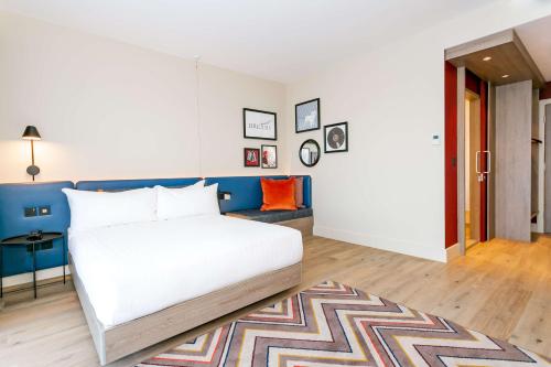 a bedroom with a white bed and a blue wall at Hampton By Hilton Blackburn in Blackburn