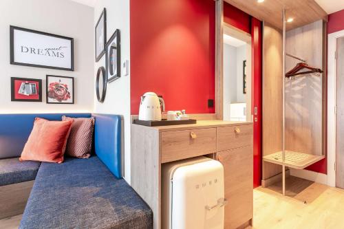 ein Badezimmer mit einer Bank, einem Waschbecken und einem Spiegel in der Unterkunft Hampton By Hilton Blackburn in Blackburn