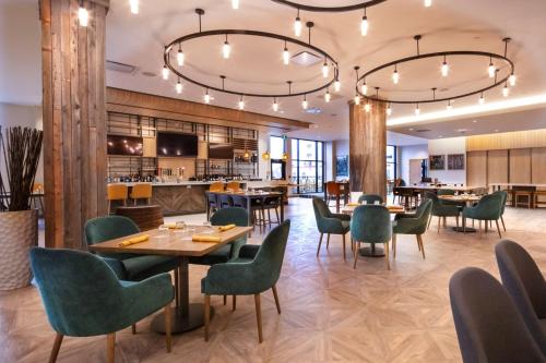 a restaurant with tables and chairs and a bar at Hilton Garden Inn Moncton Downtown, Nb in Moncton