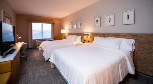 a hotel room with two beds and a flat screen tv at Hilton Garden Inn Moncton Downtown, Nb in Moncton