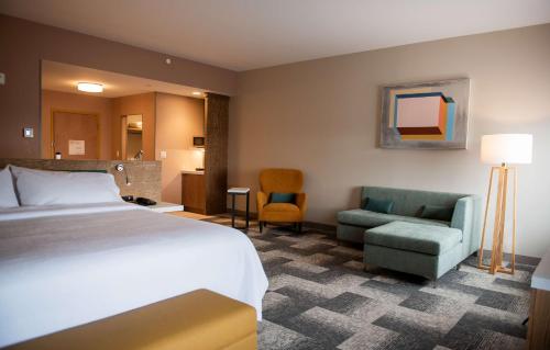 ein Hotelzimmer mit einem Bett und zwei Stühlen in der Unterkunft Hilton Garden Inn Moncton Downtown, Nb in Moncton