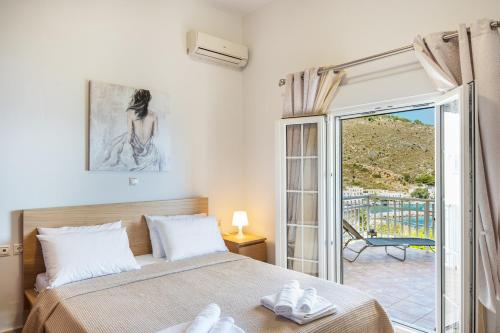 1 dormitorio con 1 cama y puerta a un balcón en Anna House, en Panteli