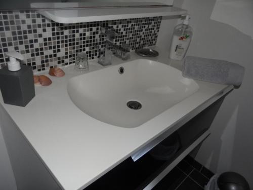 ein weißes Waschbecken im Bad mit Theke in der Unterkunft chambres d'hôtes près de FECAMP in Ganzeville
