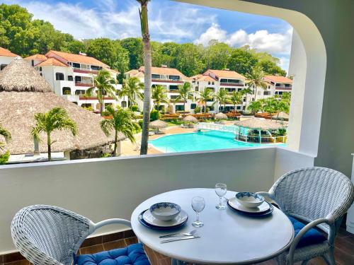 a table and chairs with a view of a pool at Flat Sea & Sun Monte Vista in Sosúa
