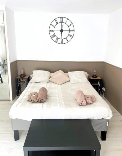 - une chambre avec un lit doté d'oreillers roses et d'une horloge dans l'établissement L ESCALE entre DISNEY et PARIS, à Villiers-sur-Marne