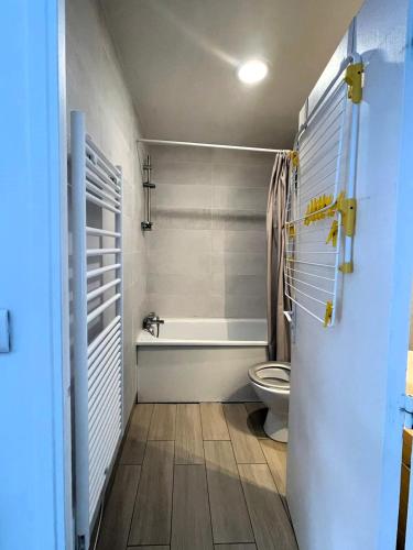 une salle de bain avec toilettes et baignoire dans l'établissement L ESCALE entre DISNEY et PARIS, à Villiers-sur-Marne