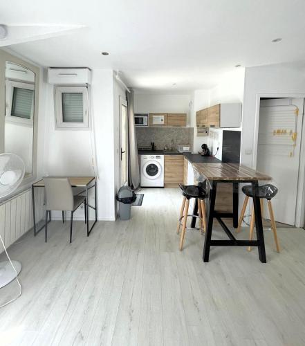 - une cuisine avec une table et des chaises en bois dans la chambre dans l'établissement L ESCALE entre DISNEY et PARIS, à Villiers-sur-Marne