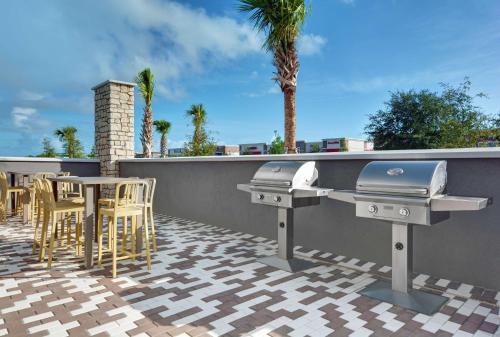 a patio with a grill and a table and chairs at Home2 Suites By Hilton Melbourne Viera in Melbourne