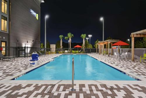 a swimming pool at night at a hotel at Home2 Suites By Hilton Melbourne Viera in Melbourne