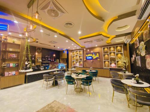 a restaurant with tables and chairs and a bar at Arkan Al Barzah Hotel Apartment in Sur