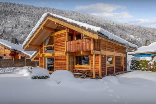 une cabane en rondins dans la neige dans l'établissement Chalet Antigone - OVO Network, à Saint-Jean-de-Sixt