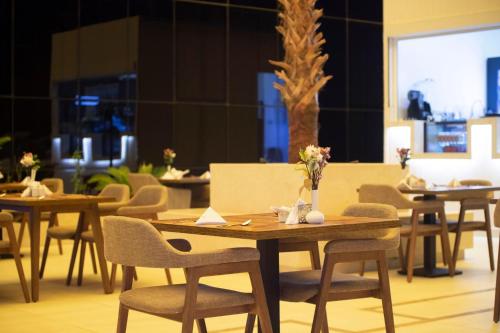 a group of tables and chairs with flowers on them at Sarwat Park Hotel Riyadh - Diplomatic Quarter in Riyadh