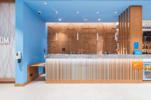 a lobby with a reception counter with wood paneling at Hampton By Hilton Warsaw Reduta in Warsaw