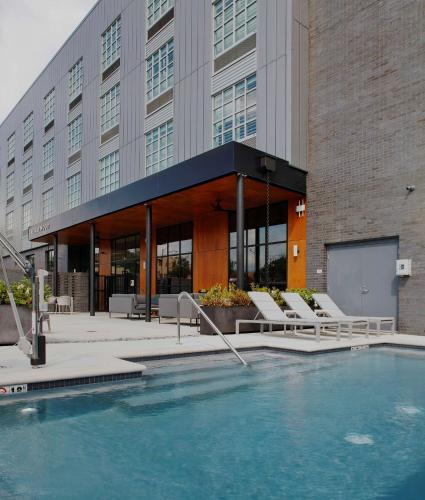 a building with a swimming pool in front of a building at The Haywood, Tapestry Collection by Hilton in El Dorado