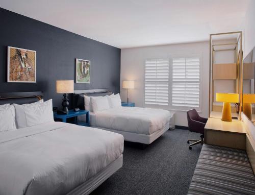 um quarto de hotel com duas camas e uma cadeira em The Haywood, Tapestry Collection by Hilton em El Dorado