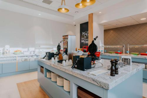 a kitchen with blue cabinets and a counter top at Hampton By Hilton Warsaw Reduta in Warsaw