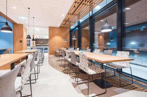 una sala da pranzo con tavoli, sedie e piscina di Hampton By Hilton Warsaw Reduta a Varsavia