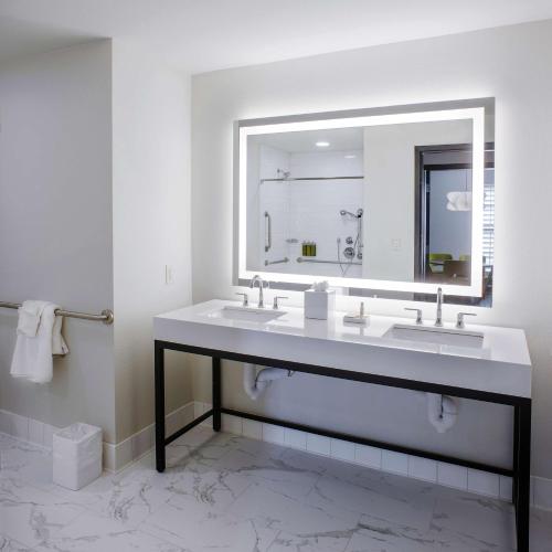 baño con 2 lavabos y espejo grande en The Haywood, Tapestry Collection by Hilton en El Dorado