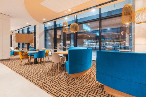 a dining area with blue chairs and tables in a restaurant at Hampton By Hilton Warsaw Reduta in Warsaw