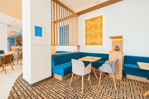 a room with a blue couch and chairs and a table at Hampton By Hilton Warsaw Reduta in Warsaw
