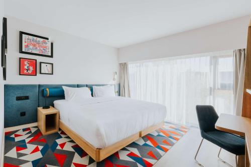 a bedroom with a bed and a desk and a chair at Hampton By Hilton Warsaw Reduta in Warsaw