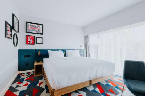 a bedroom with a large bed and a chair at Hampton By Hilton Warsaw Reduta in Warsaw