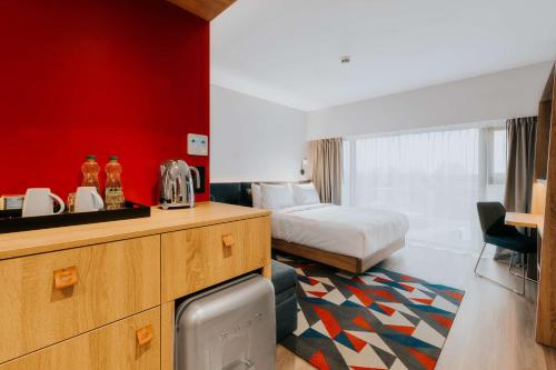 a hotel room with a bed and a red wall at Hampton By Hilton Warsaw Reduta in Warsaw
