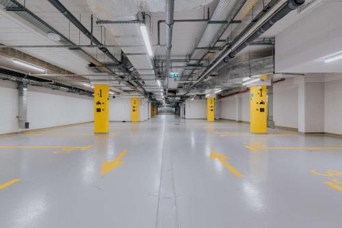 an empty parking garage with yellow arrows on the floor at Hampton By Hilton Warsaw Reduta in Warsaw