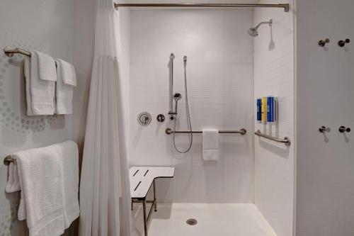 baño blanco con ducha y lavamanos en Tru By Hilton Franklin Cool Springs Nashville, Tn en Franklin
