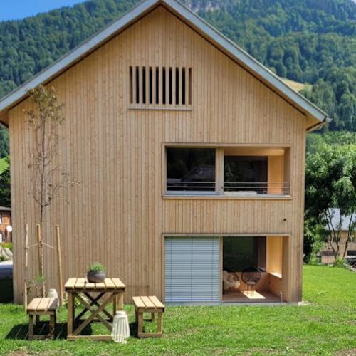 a house with a large window and a garage at Haus im WALDner in Mellau