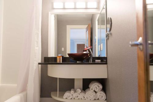 W łazience znajduje się umywalka, lustro i ręczniki. w obiekcie Capitol Plaza Hotel Montpelier Tapestry Collection by Hilton w mieście Montpelier