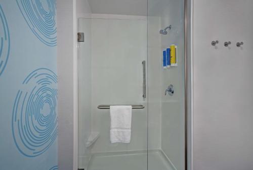 baño con ducha y puerta de cristal en Tru By Hilton Stoughton en Stoughton