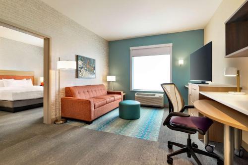 a hotel room with a bed and a desk and chair at Home2 Suites By Hilton Ogden in Ogden