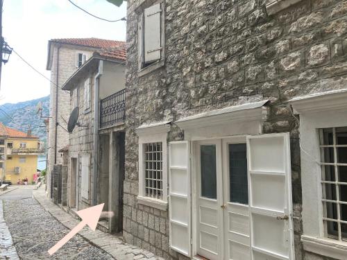 a brick building with a pink arrow on a street at Old Risan Apartment in Risan