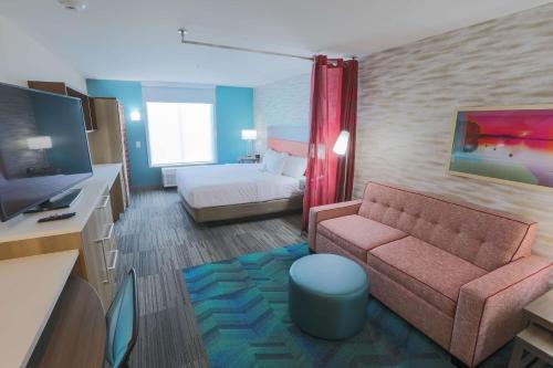 um quarto de hotel com um sofá e uma cama em Home2 Suites By Hilton Cumming Atlanta, Ga em Cumming