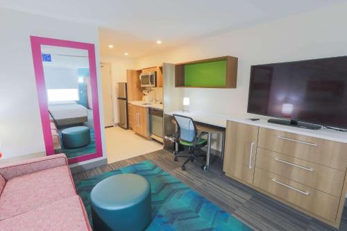 a room with a living room with a desk and a television at Home2 Suites By Hilton Cumming Atlanta, Ga in Cumming