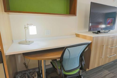 a desk in a room with a chair and a television at Home2 Suites By Hilton Cumming Atlanta, Ga in Cumming