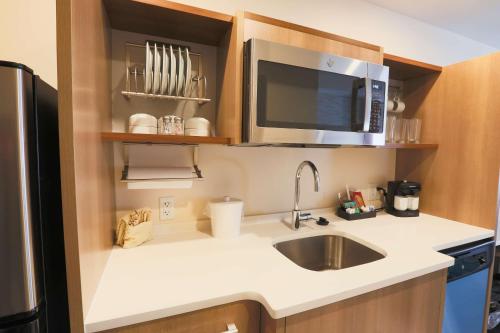 a small kitchen with a sink and a microwave at Home2 Suites By Hilton Cumming Atlanta, Ga in Cumming