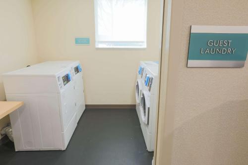 a laundry room with a guest laundry sign on a wall at Home2 Suites By Hilton Cumming Atlanta, Ga in Cumming
