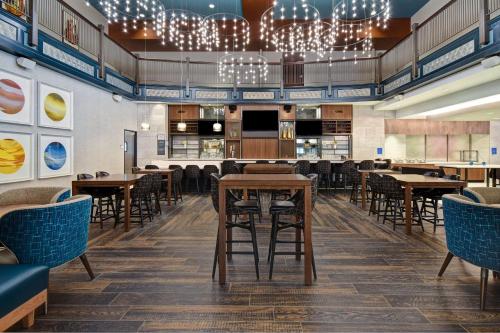 a restaurant with tables and chairs and a bar at Hilton Garden Inn Kalamazoo Downtown in Kalamazoo