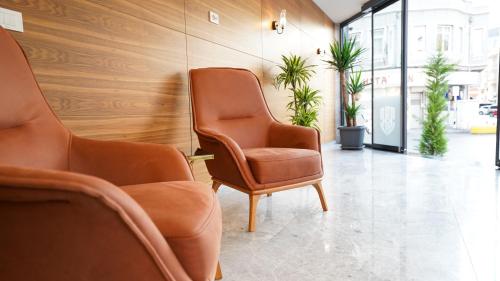 two chairs in a waiting room with plants at Bellezza Hotel in Istanbul