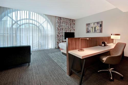 a hotel room with a desk and a bed at Hilton Garden Inn Kalamazoo Downtown in Kalamazoo