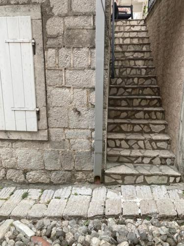 a stone staircase with a white door on a brick building at Old Risan Apartment in Risan