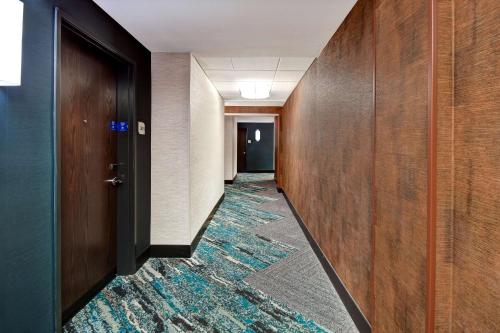 a hallway with a carpet on the floor and a door at Hilton Garden Inn Kalamazoo Downtown in Kalamazoo